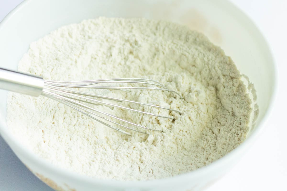 Crusty No Knead Bread | thewendthousekitchen.com Dry ingredients mixed in a mixing bowl with a whisk