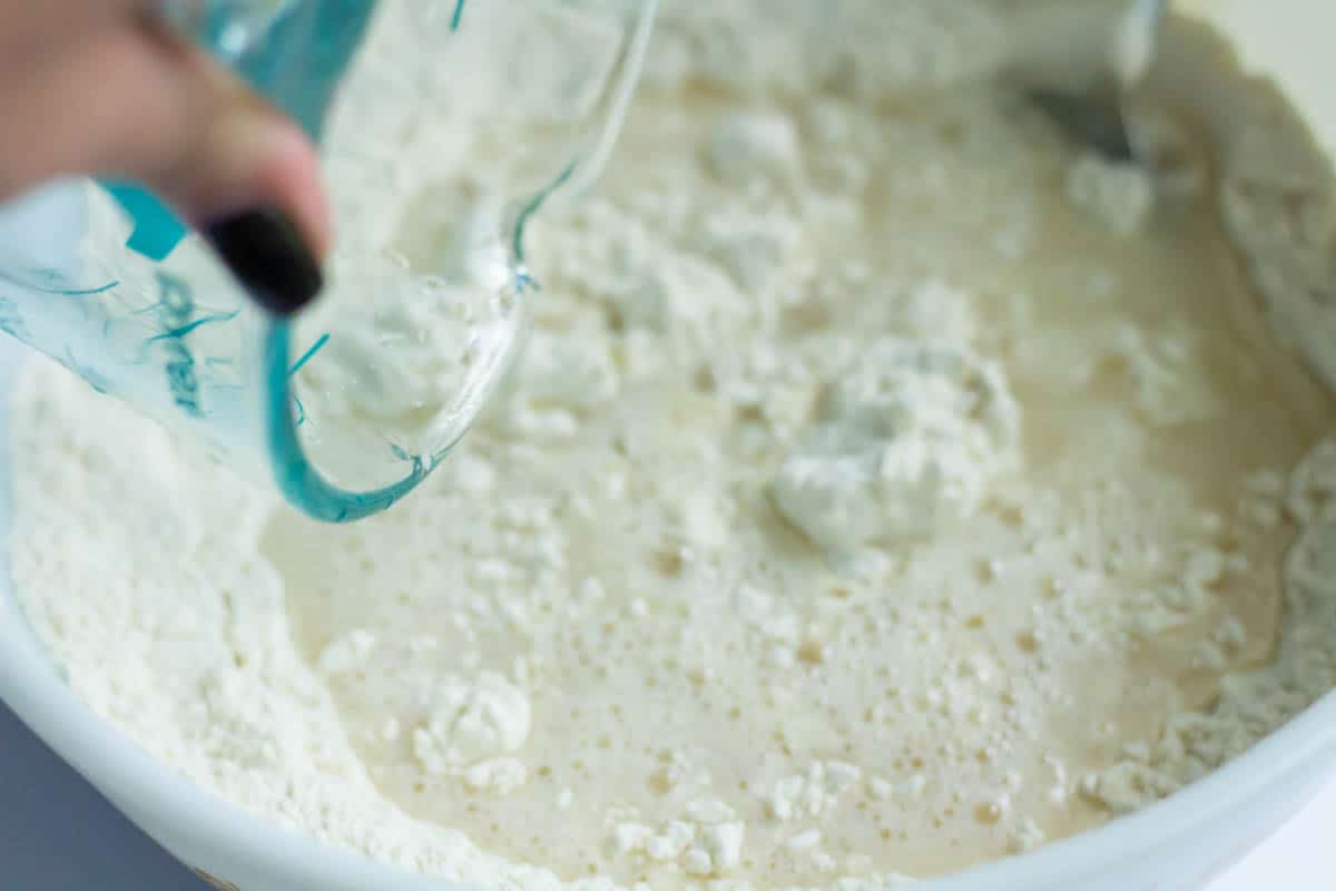 Crusty No Knead Bread | thewendthousekitchen.com Adding water to dry ingredients in a mixing bowl
