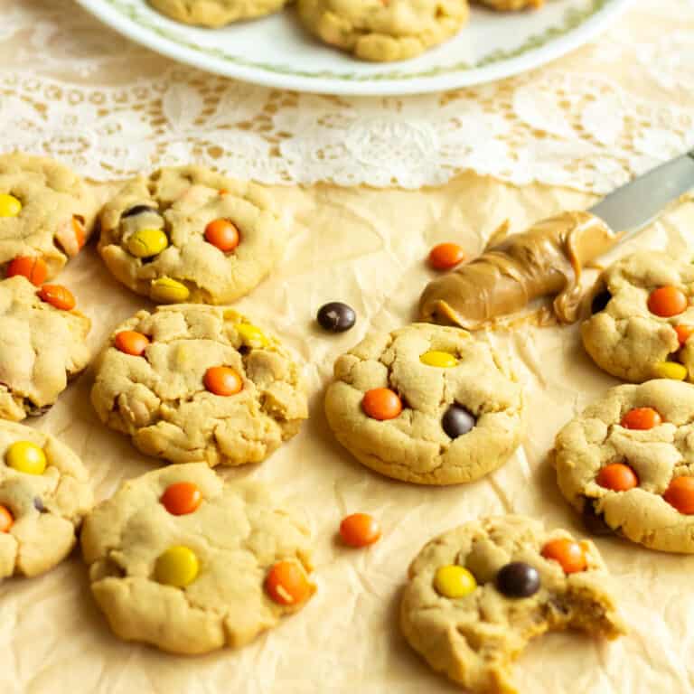 Peanut butter blast cookies on brown parchment with peanut butter on a knife in the background