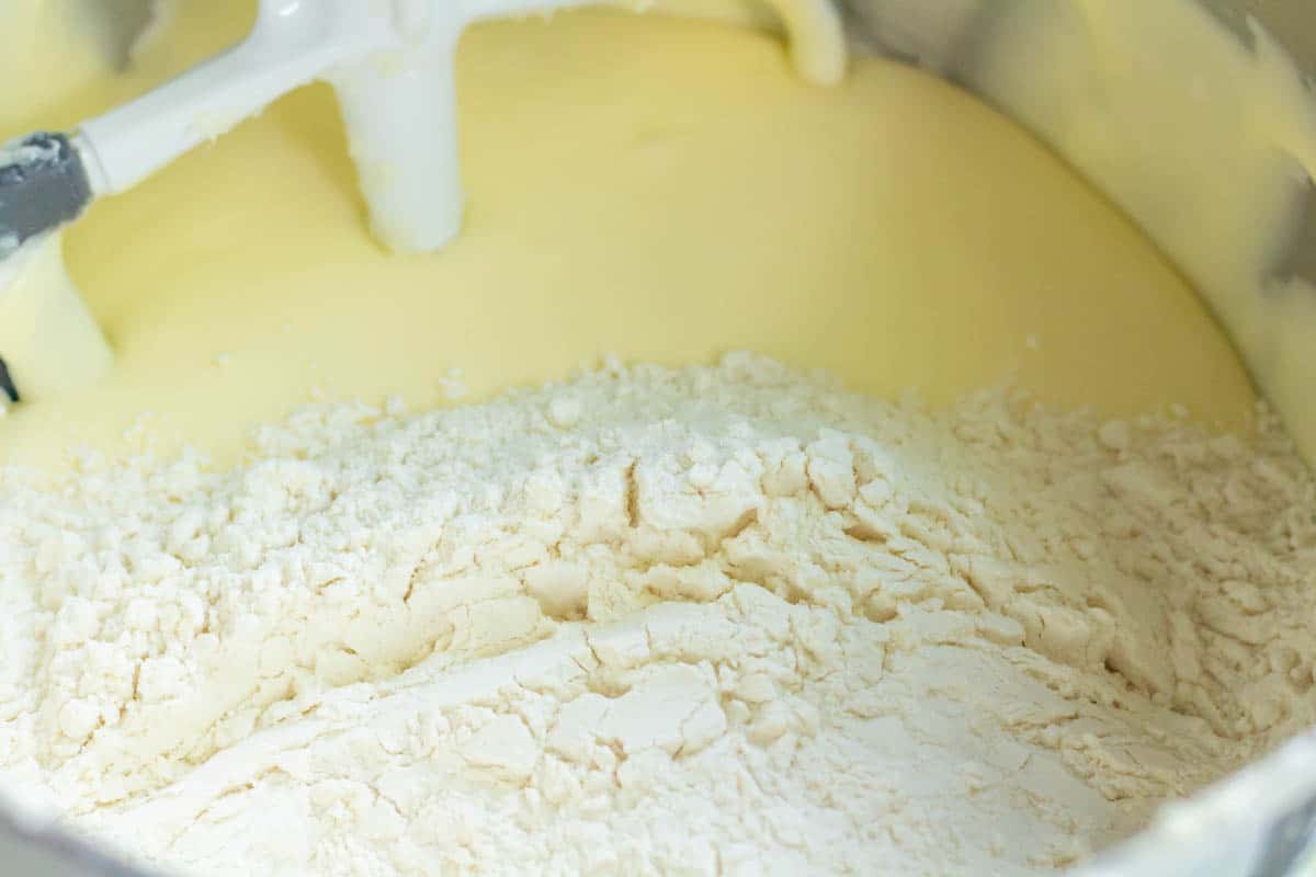 The Best Blueberry Cream Cheese Muffins | thewendthousekitchen.com Flour mixture added to the wet ingredients in the bowl of a stand mixer