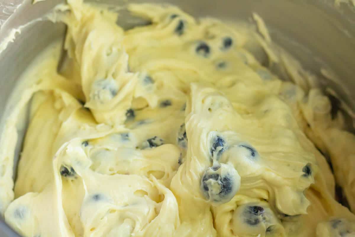 The Best Blueberry Cream Cheese Muffins | thewendthousekitchen.com Muffin batter combined with blueberries in the bowl of a stand mixer