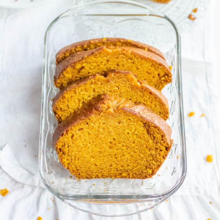 Pumpkin loaf cake in slices inside of a glass loaf pan