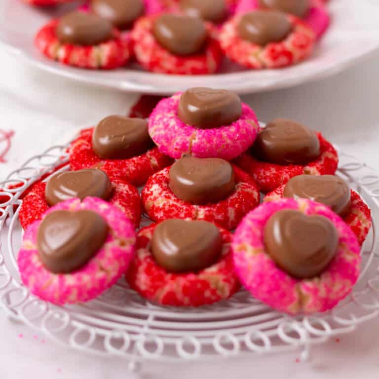 Valentine's Day Sugar Cookie Blossoms on a small white grid with cookies on a white plate in the background