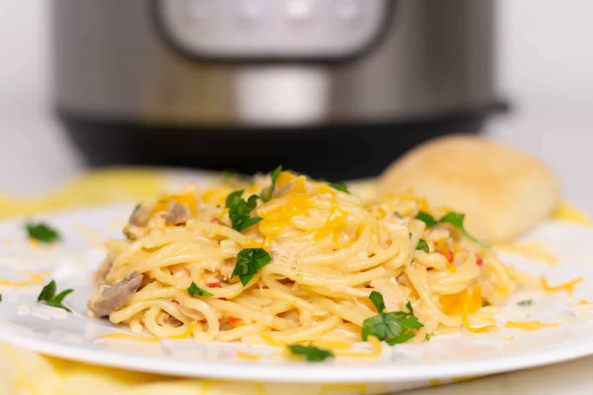 Photo of chicken spaghetti on a white plate with an Instant Pot in the background