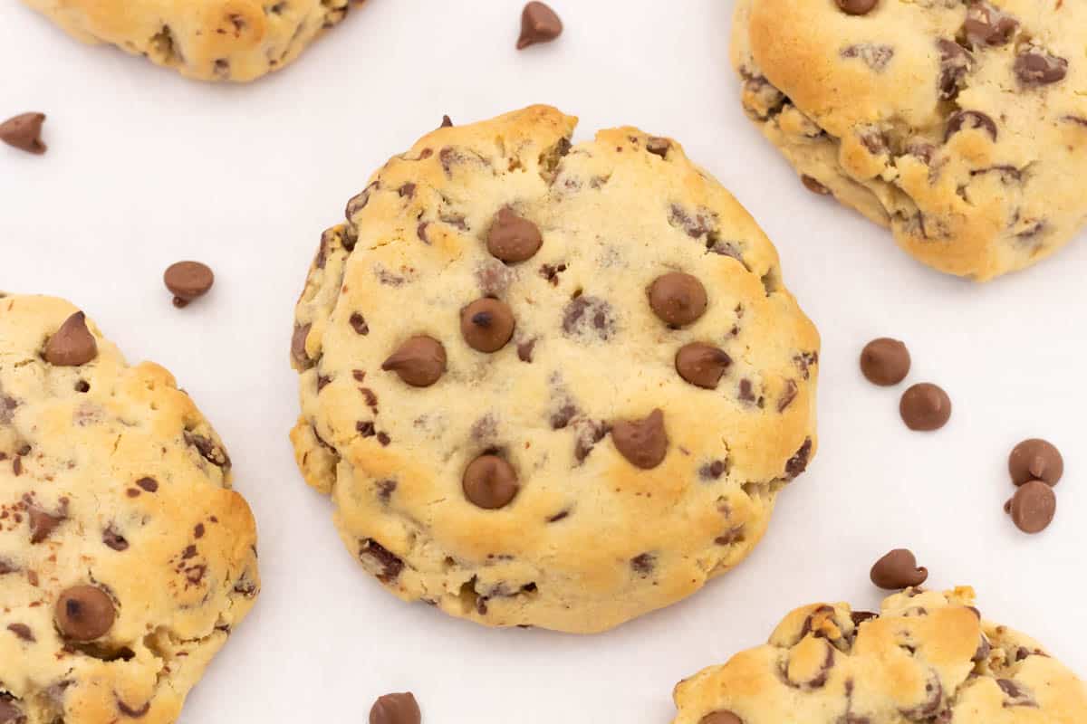 Overhead shot of chocolate chip cookies and chocolate chips surrounding them