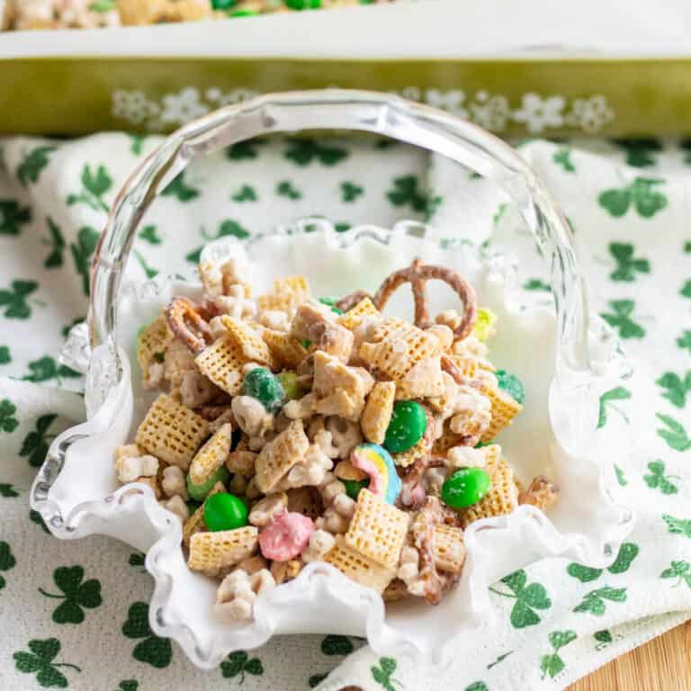 Leprechaun bait in a white glass candy dish on a white towel with green shamrocks