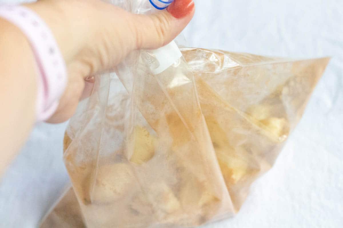 Shaking a bag filled with cut up rolls and cinnamon sugar