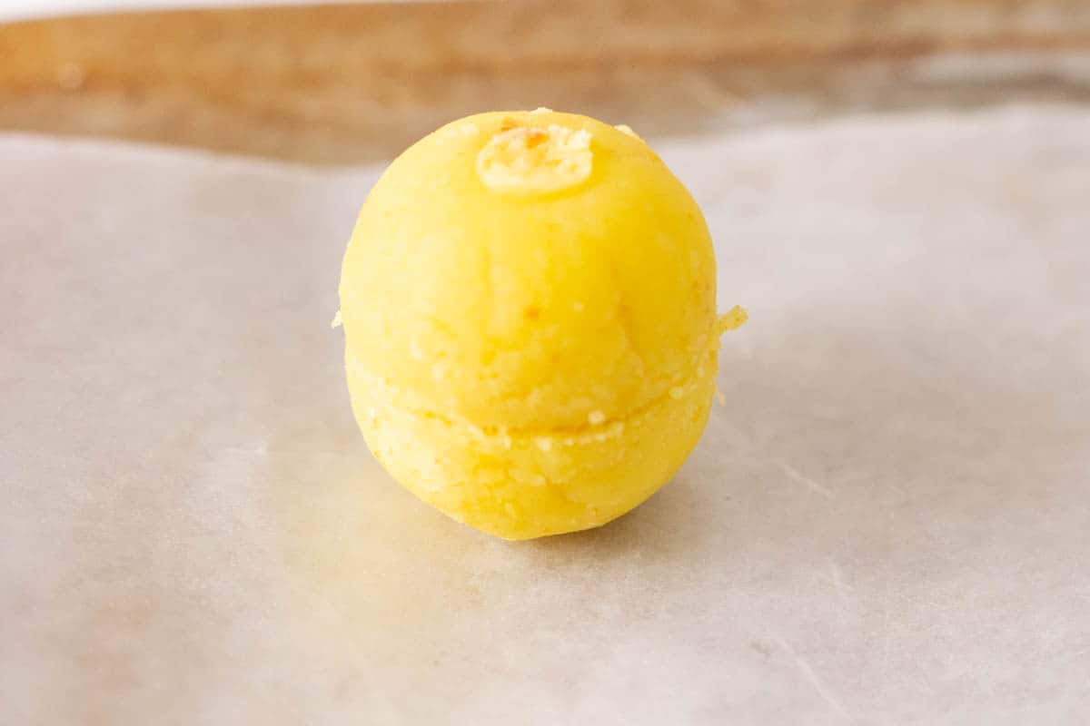 One cake pop on a cookie sheet lined with waxed paper