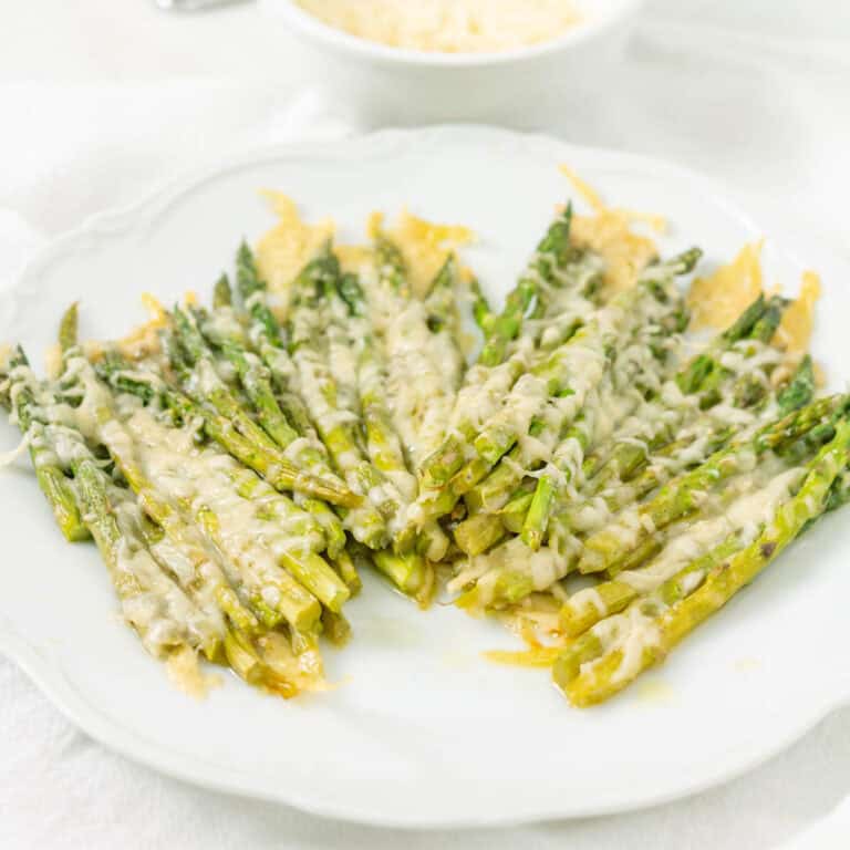 Roasted parmesan asparagus arranged on a white plate