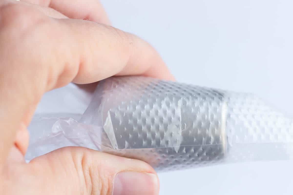 A Russian piping tip inside of a piping bag with a line made with a scissor to show where to cut the piping bag
