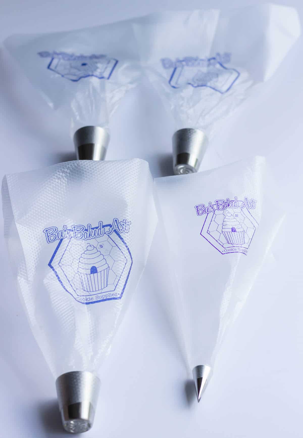 Four piping bags with piping tips fitted inside