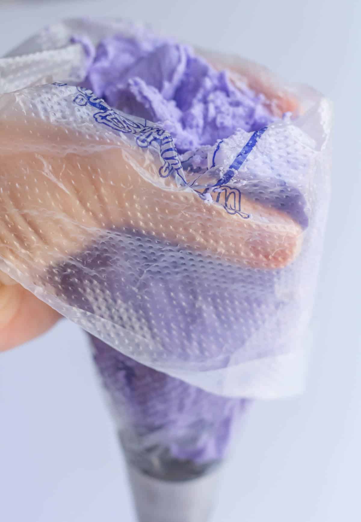 A 16-inch piping bag filled halfway with lavender buttercream and fitted with a piping tip