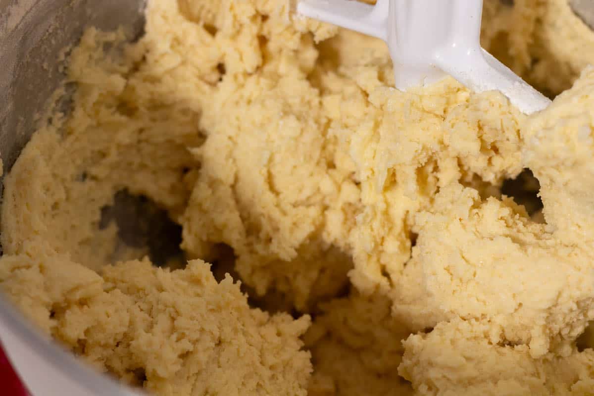 Sugar, butter, eggs, flour, baking soda and salt mixed together in the bowl of a stand mixer.