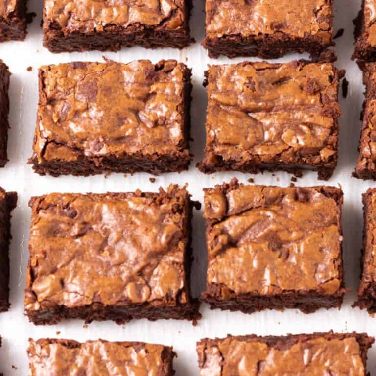 Fudgy brownies sliced and arranged on white parchment