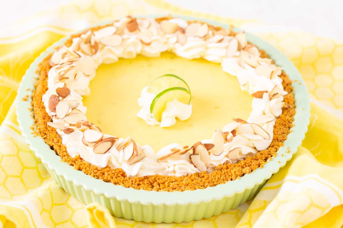 Key Lime Pie with whipped cream and almonds in a green pie shell