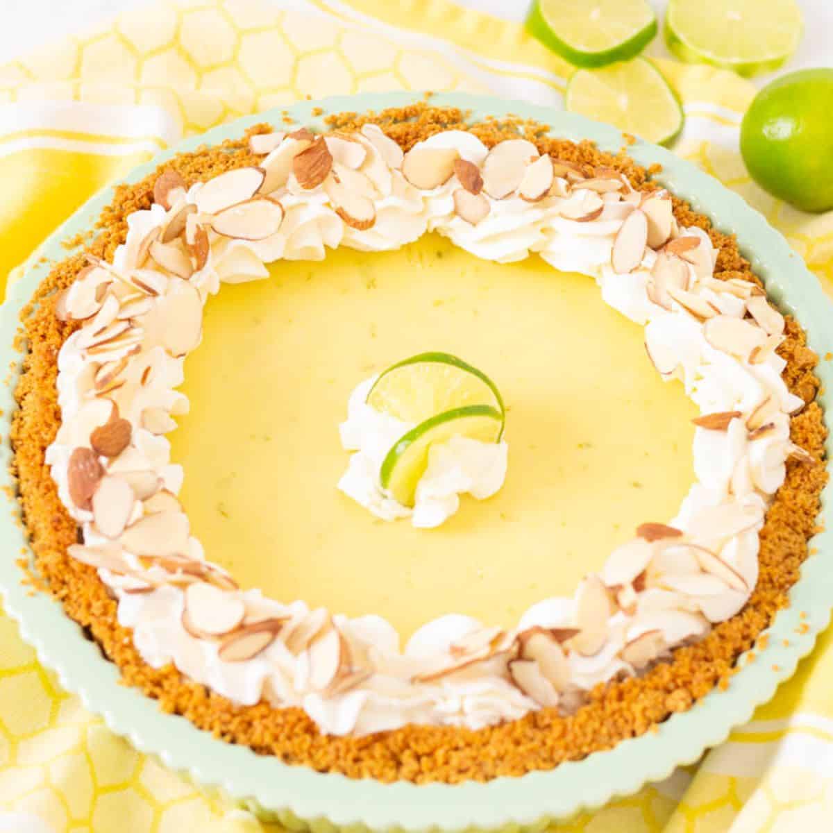 Key lime pie with whipped cream in a green pie plate