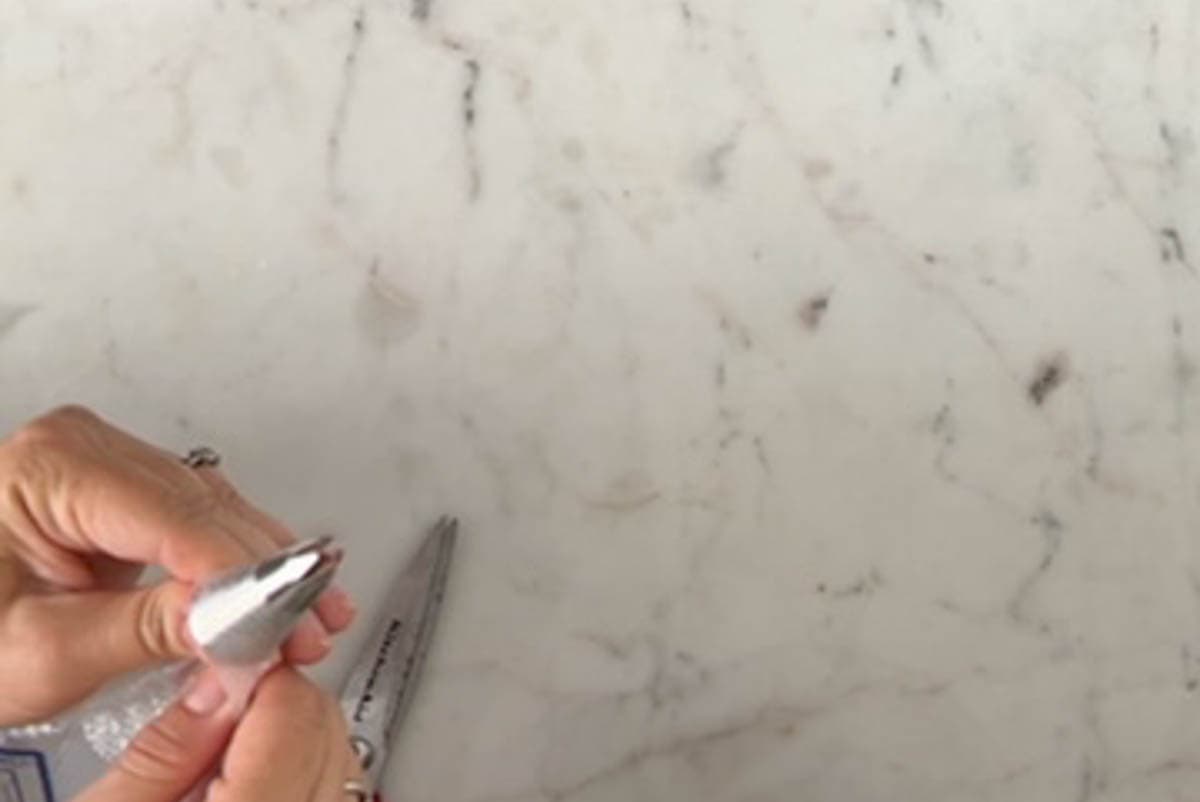 Pushing a piping tip down into the hole of a pastry bag