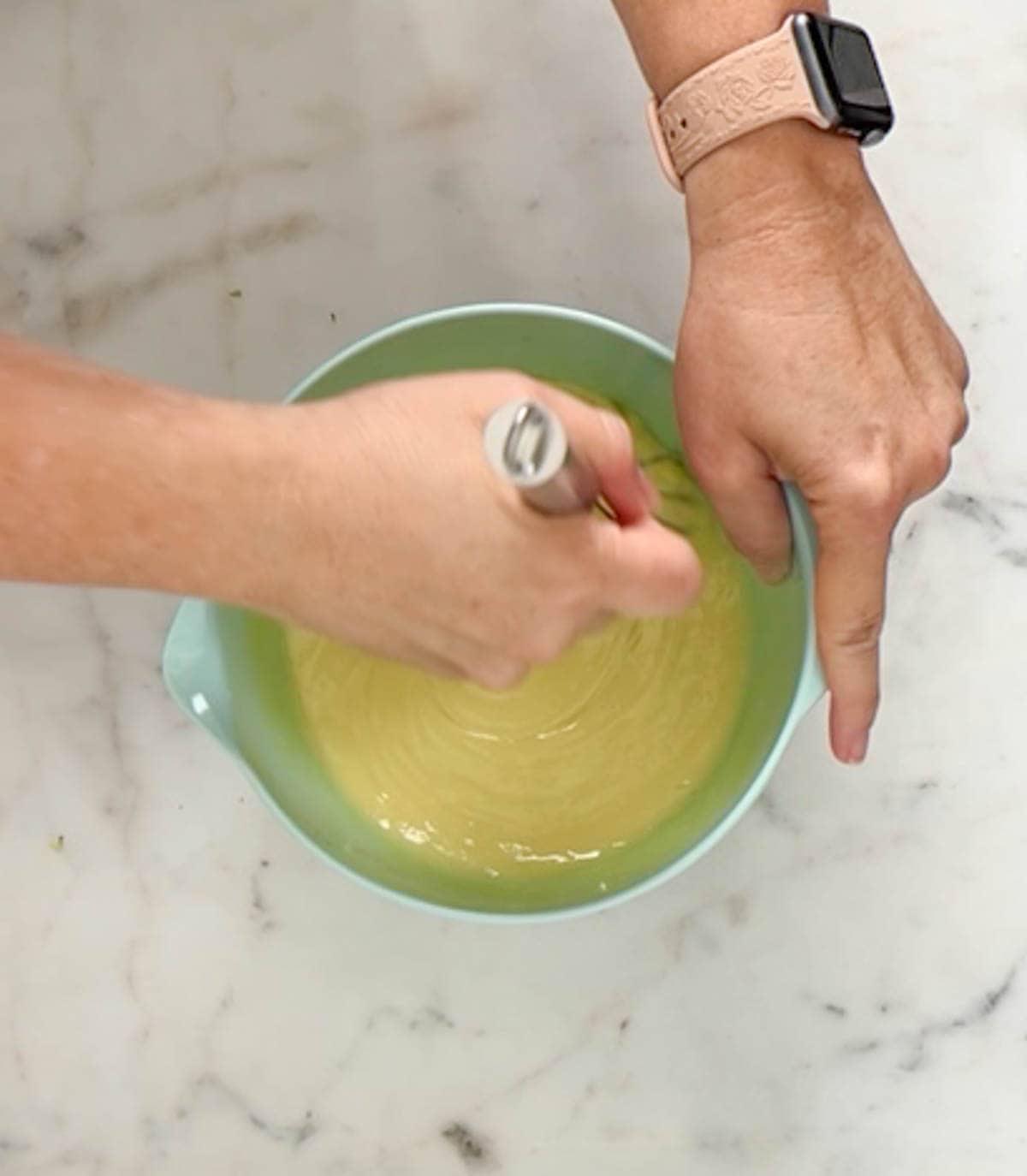 Mixing sweetened condensed milk into egg yolks and lime juice with a whisk