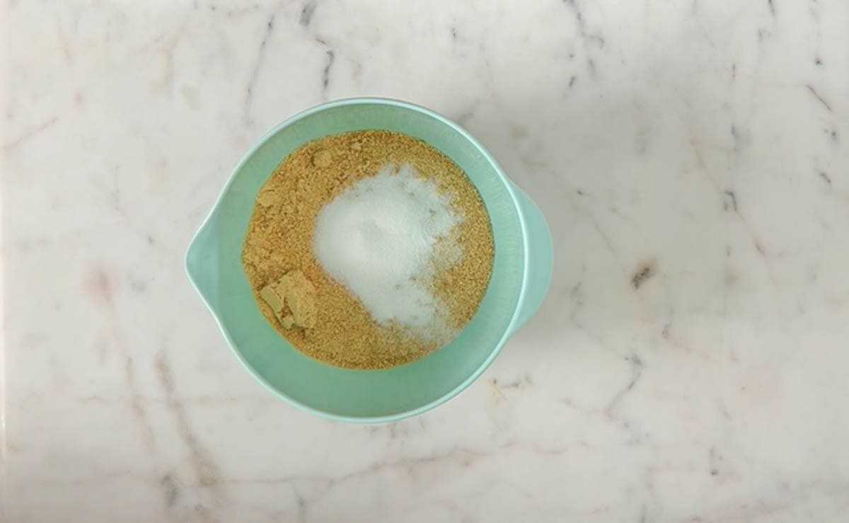 Graham cracker crumbs and sugar in a medium aqua mixing bowl