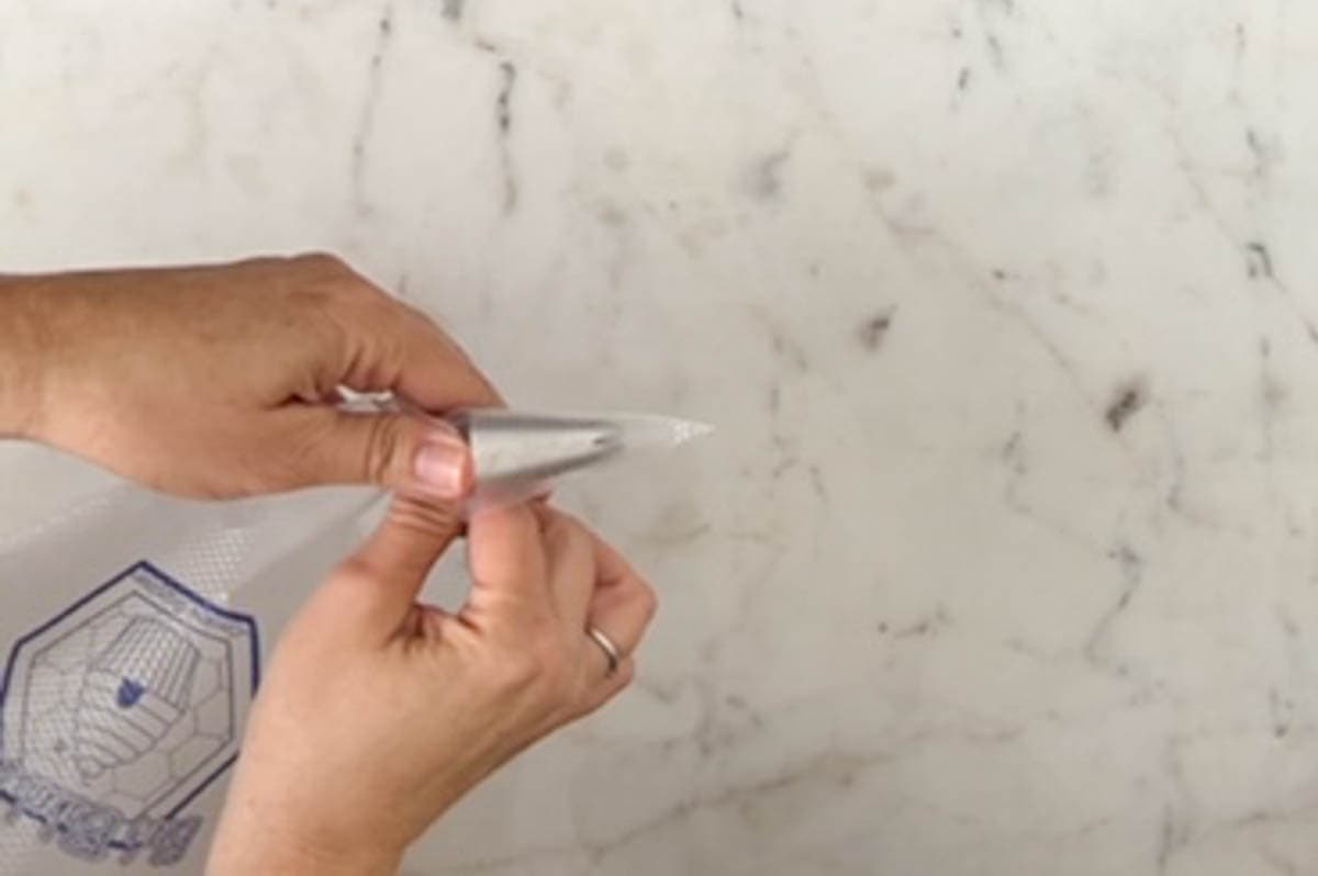 Pushing a piping tip into a large disposable pastry bag