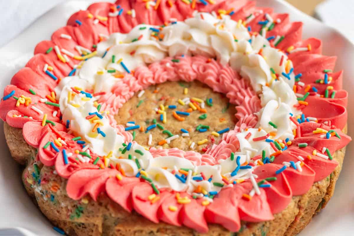 Decorated cookie cake on a white cake pedestal.