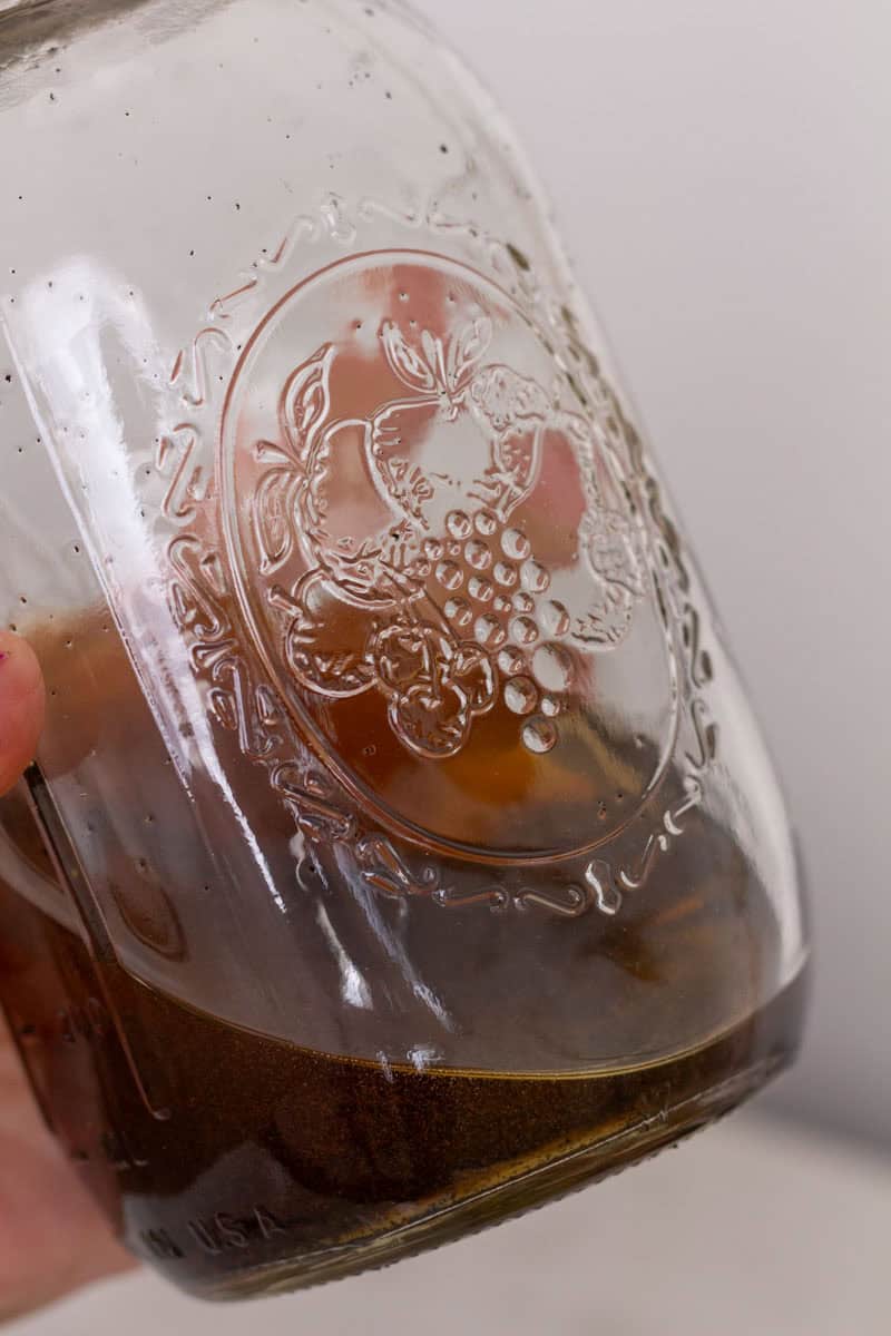 Easy Bourbon Vanilla Extract | thewendthousekitchen.com Vanilla extract inside of a large glass Mason jar.