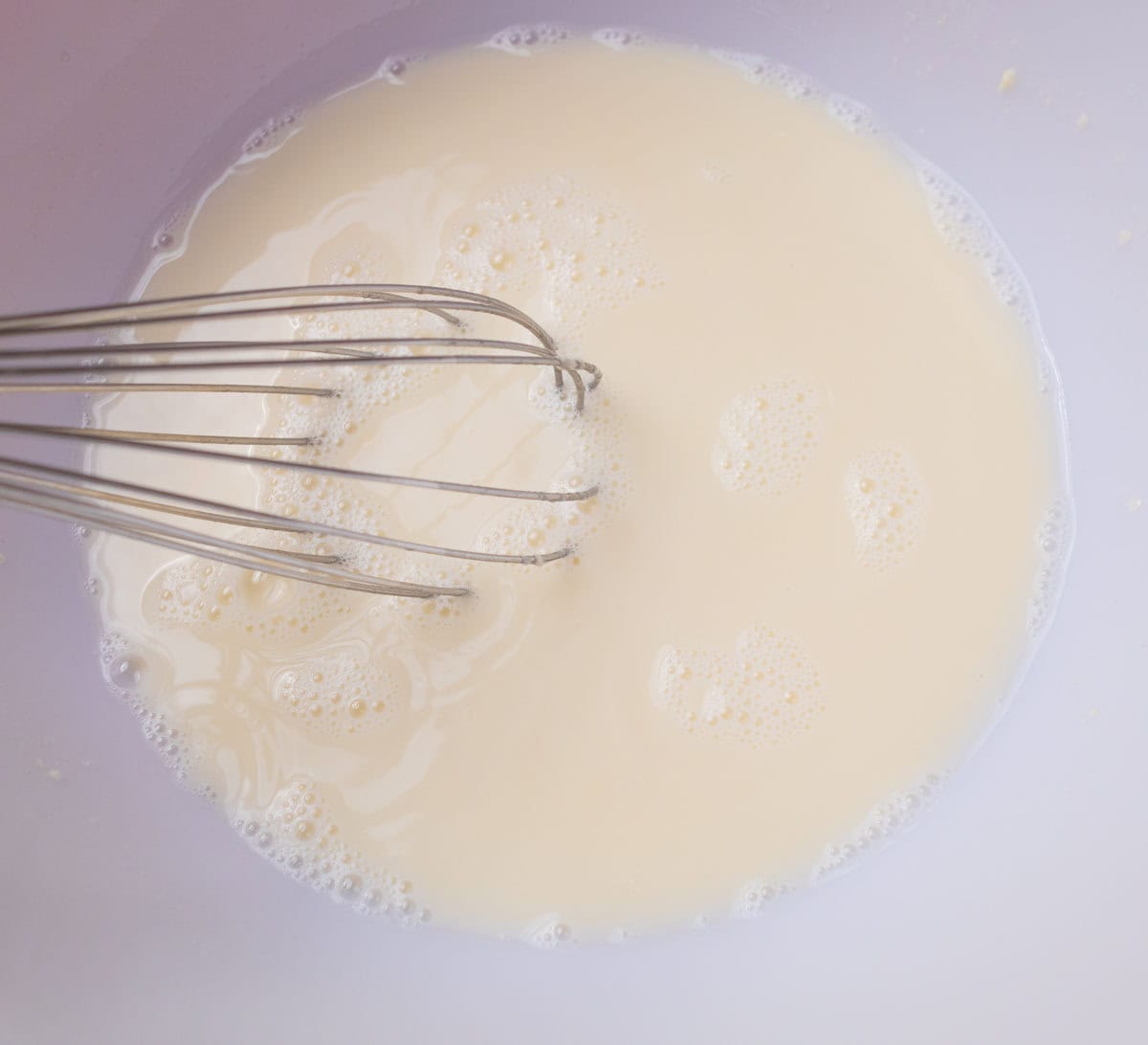 How To Make Artisan Sourdough Bread | thewendthousekitchen.com Sourdough starter and water whisked together in a large bowl.