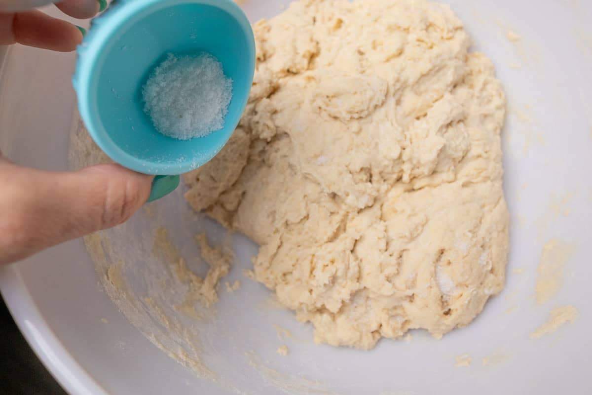 How To Make Sourdough Starter | thewendthousekitchen.com Adding salt to flour, starter and water mixture.