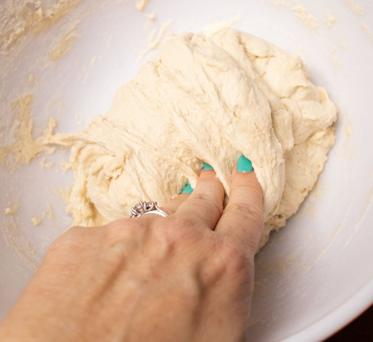 How To Make Artisan Sourdough Bread | thewendthousekitchen.com Folding dough over onto itself to incorporate salt.