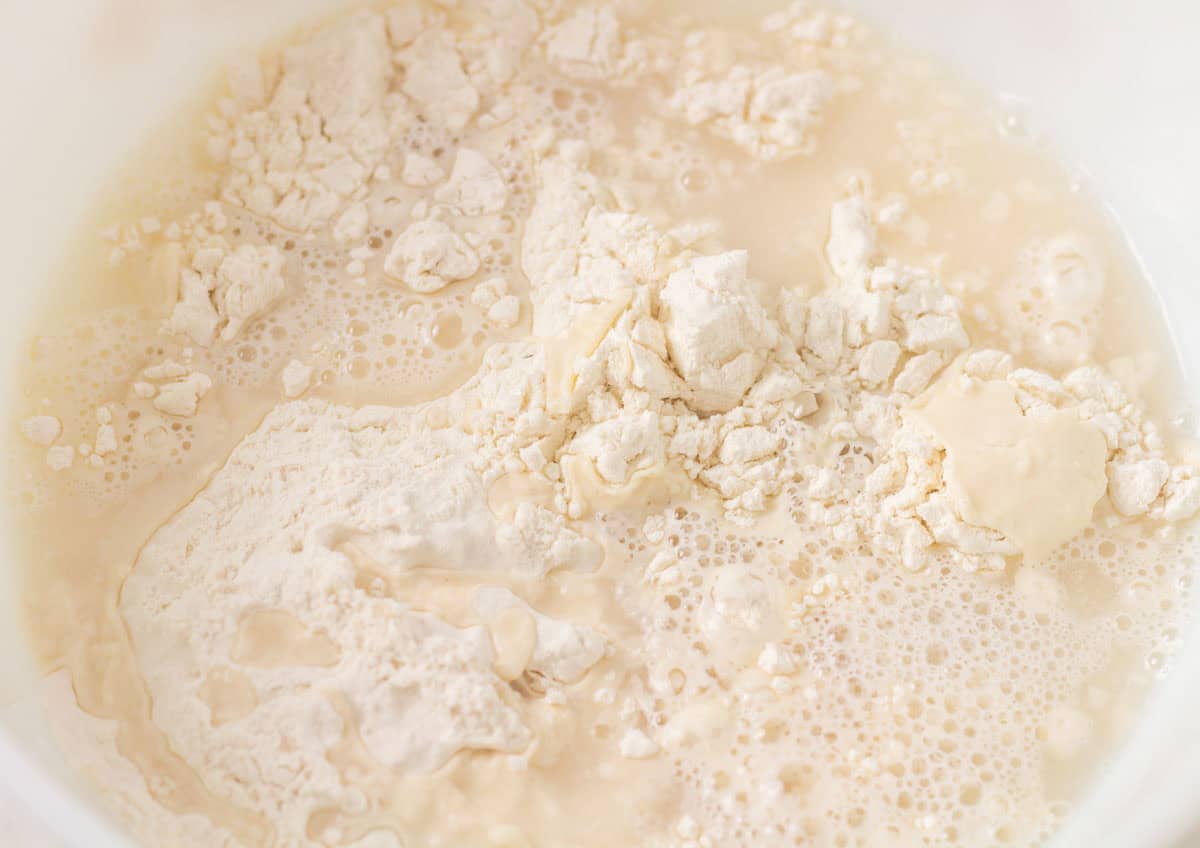 How To Make Artisan Sourdough Bread | thewendthousekitchen.com Water added to a bowl with flour.