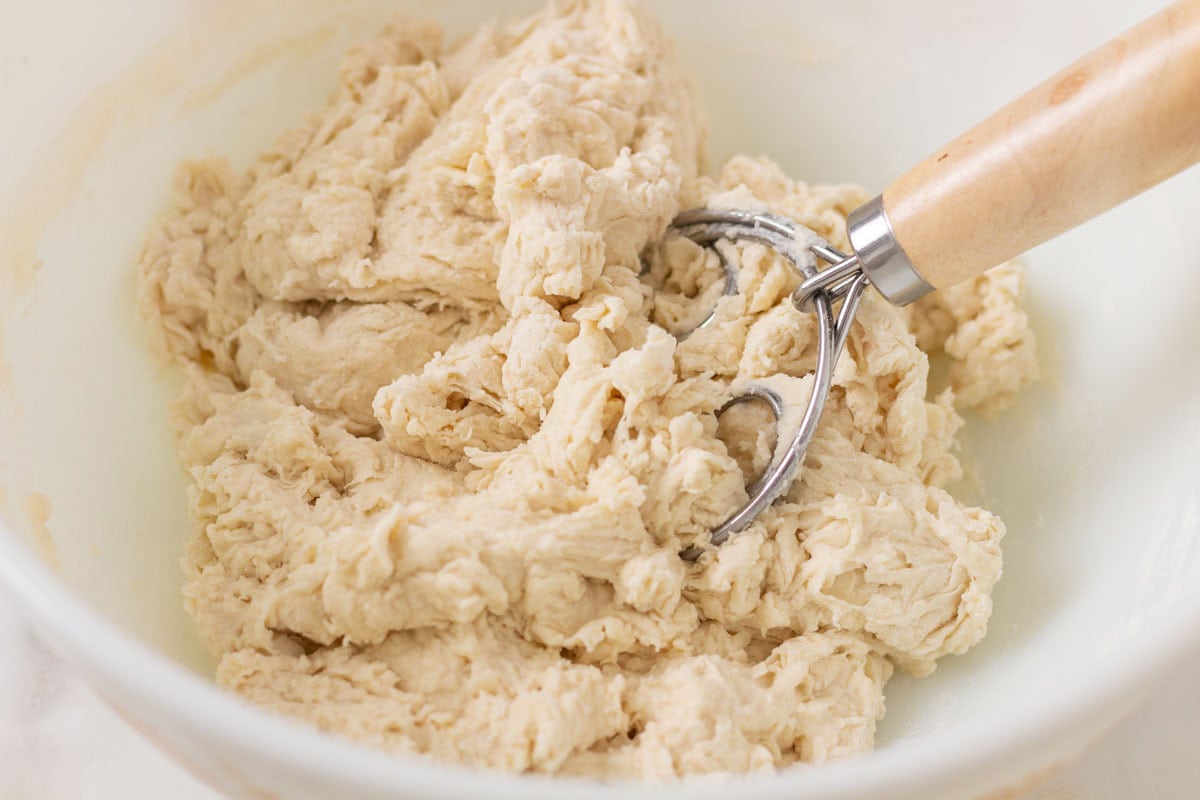 How To Make Artisan Sourdough Bread | thewendthousekitchen.com Flour and water in a bowl mixed together with a bread whisk.