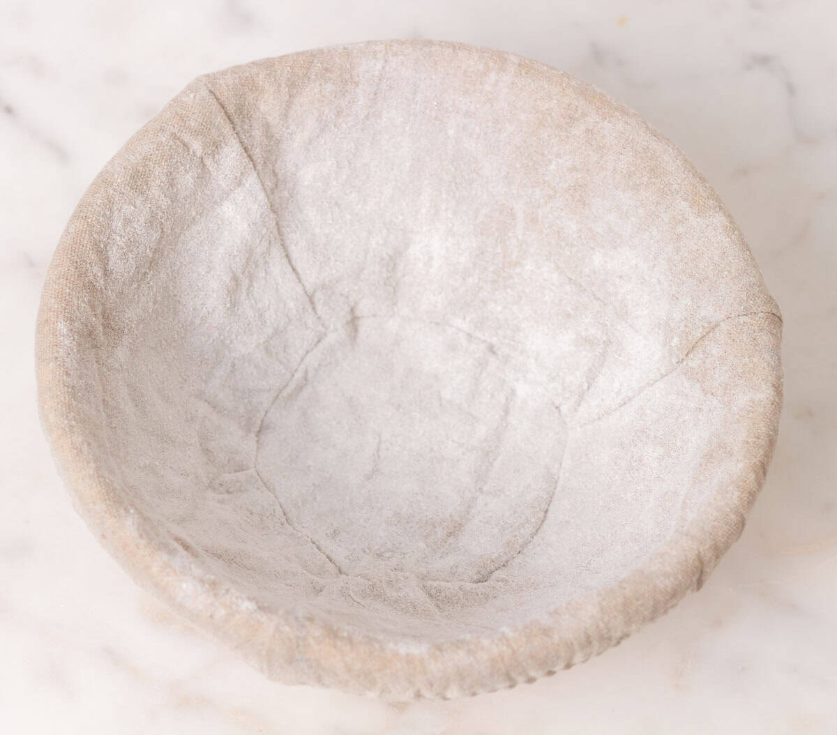 How To Make Artisan Sourdough Bread | thewendthousekitchen.com A floured lined banneton bowl.
