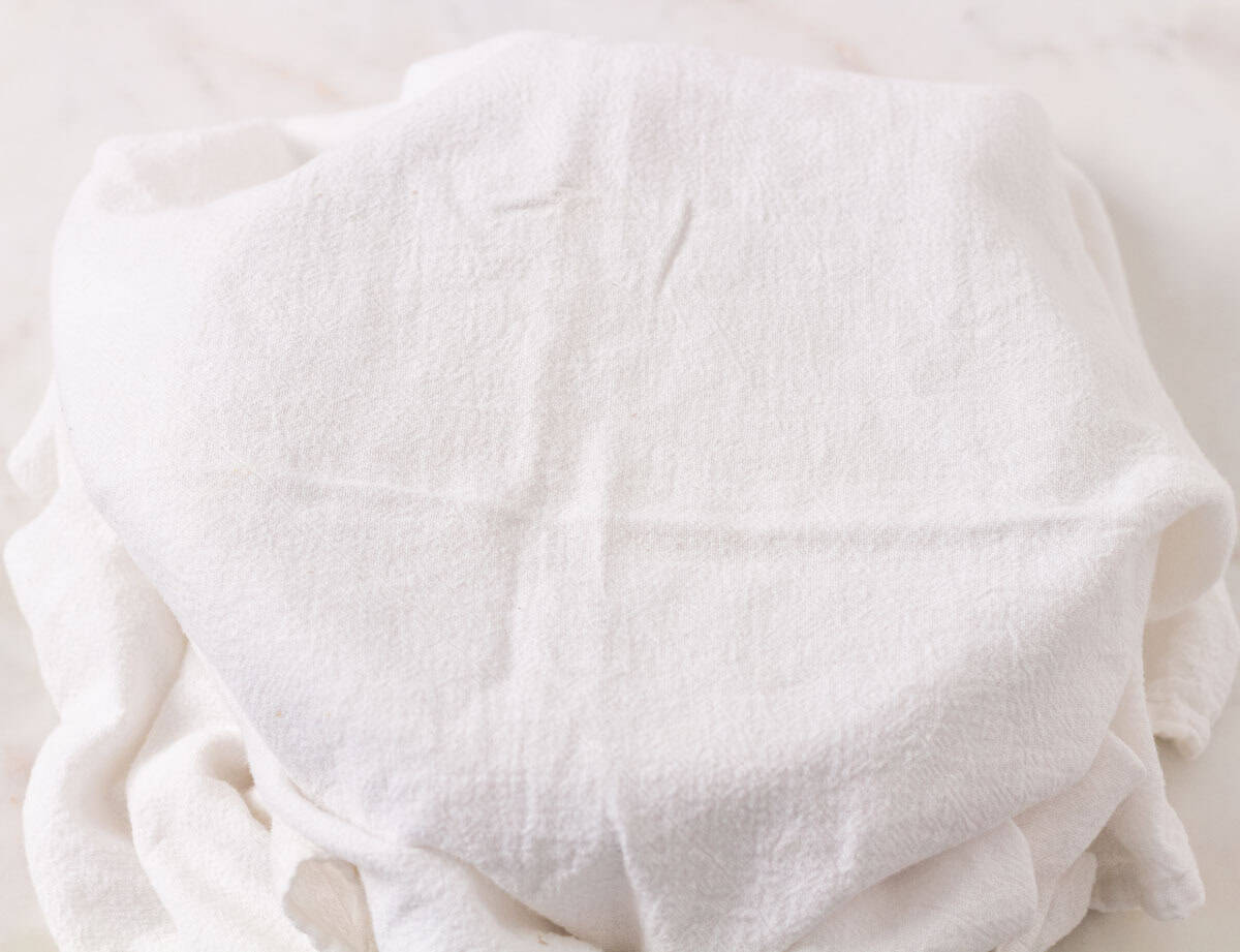 How To Make Artisan Sourdough Bread | thewendthousekitchen.com White tea towel covering a bowl with sourdough.