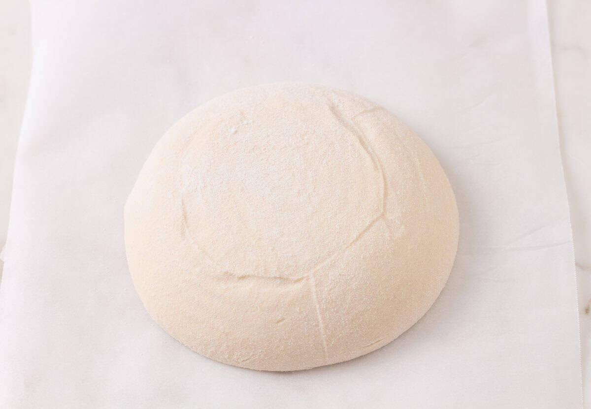 How To Make Artisan Sourdough Bread | thewendthousekitchen.com Sourdough turned out onto a large piece of parchment paper.