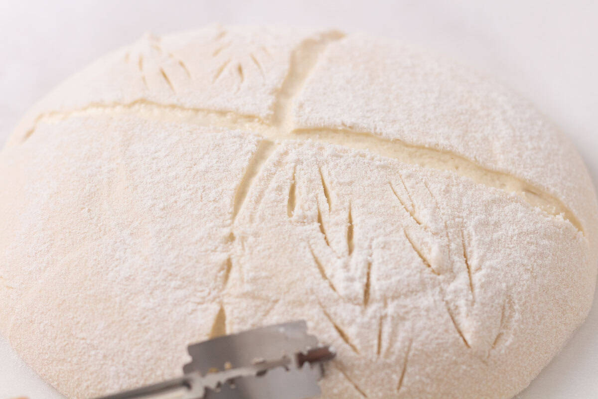 How To Make Artisan Sourdough Bread | thewendthousekitchen.com Scoring decorations onto sourdough bread with a lame.