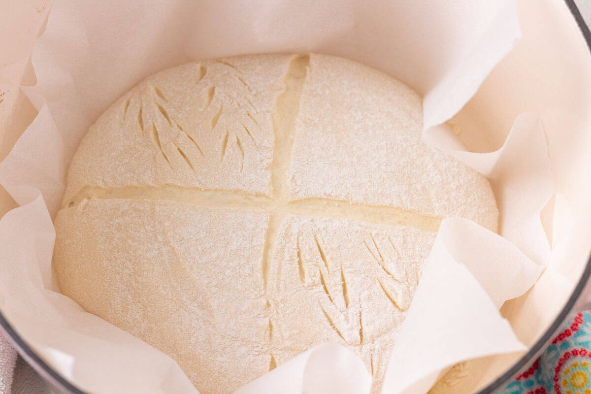 How To Make Artisan Sourdough Bread | thewendthousekitchen.com Unbaked sourdough inside a parchment-lined Dutch oven.