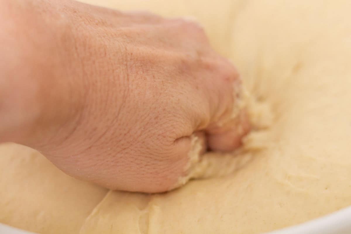Sour Dough Discard Cinnamon Rolls | thewendthousekitchen.com Punching down dough that has risen.