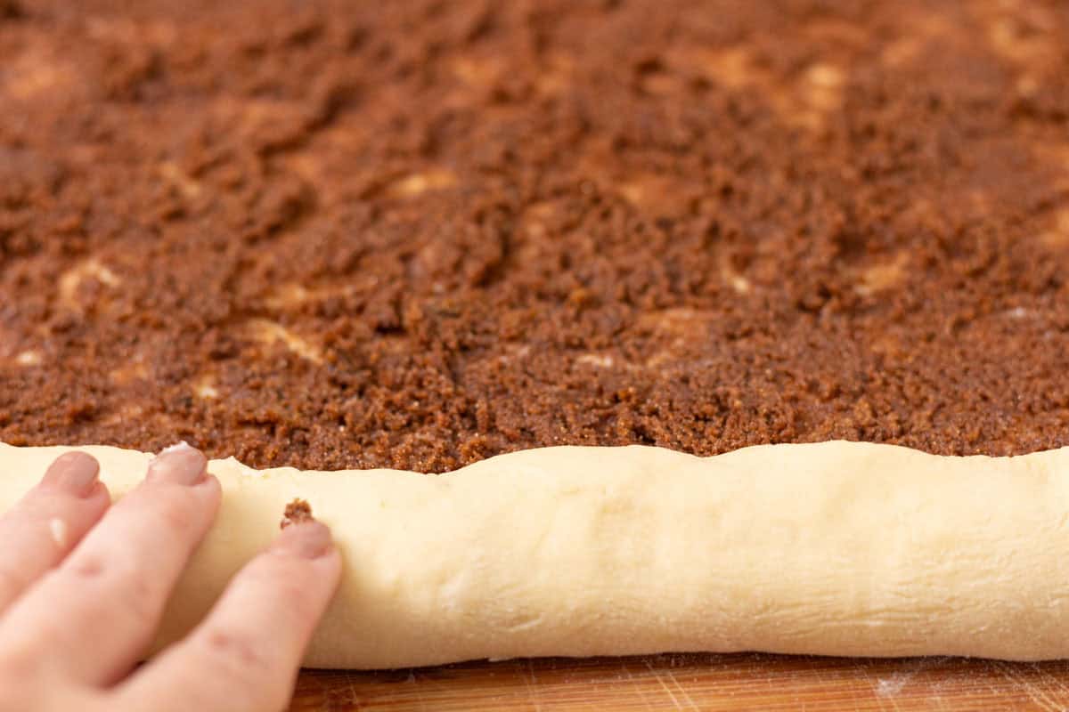 Sour Dough Discard Cinnamon Rolls | thewendthousekitchen.com Rolling cinnamon roll dough into a log.