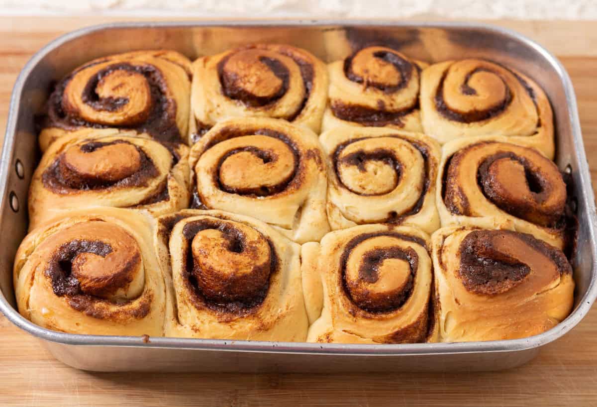 Sour Dough Discard Cinnamon Rolls | thewendthousekitchen.com Baked cinnamon rolls in a metal pan.