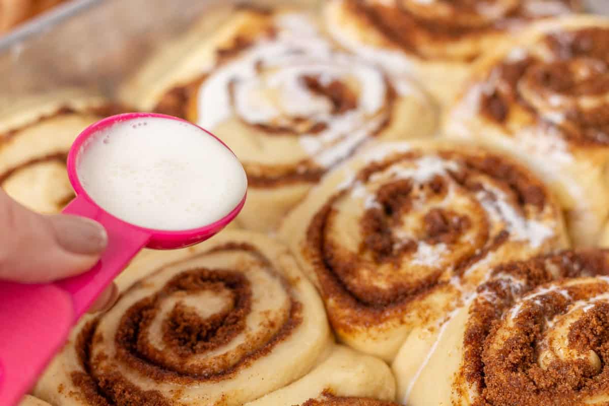 Sour Dough Discard Cinnamon Rolls | thewendthousekitchen.com Drizzling heavy cream over raw cinnamon rolls.