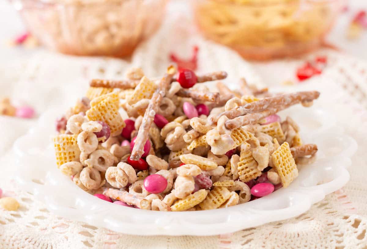 Valentine bait snack mix on a white plate on a lace apron