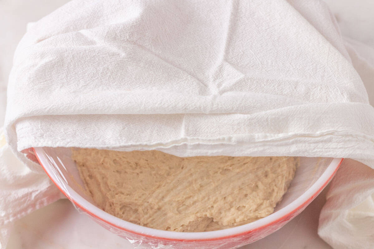 Sourdough Discard English Muffin Recipe | thewendthousekitchen.com Sourdough discard, milk, sugar, all-purpose flour and butter combined together in a large mixing bowl and covered with plastic wrap and a tea towel.