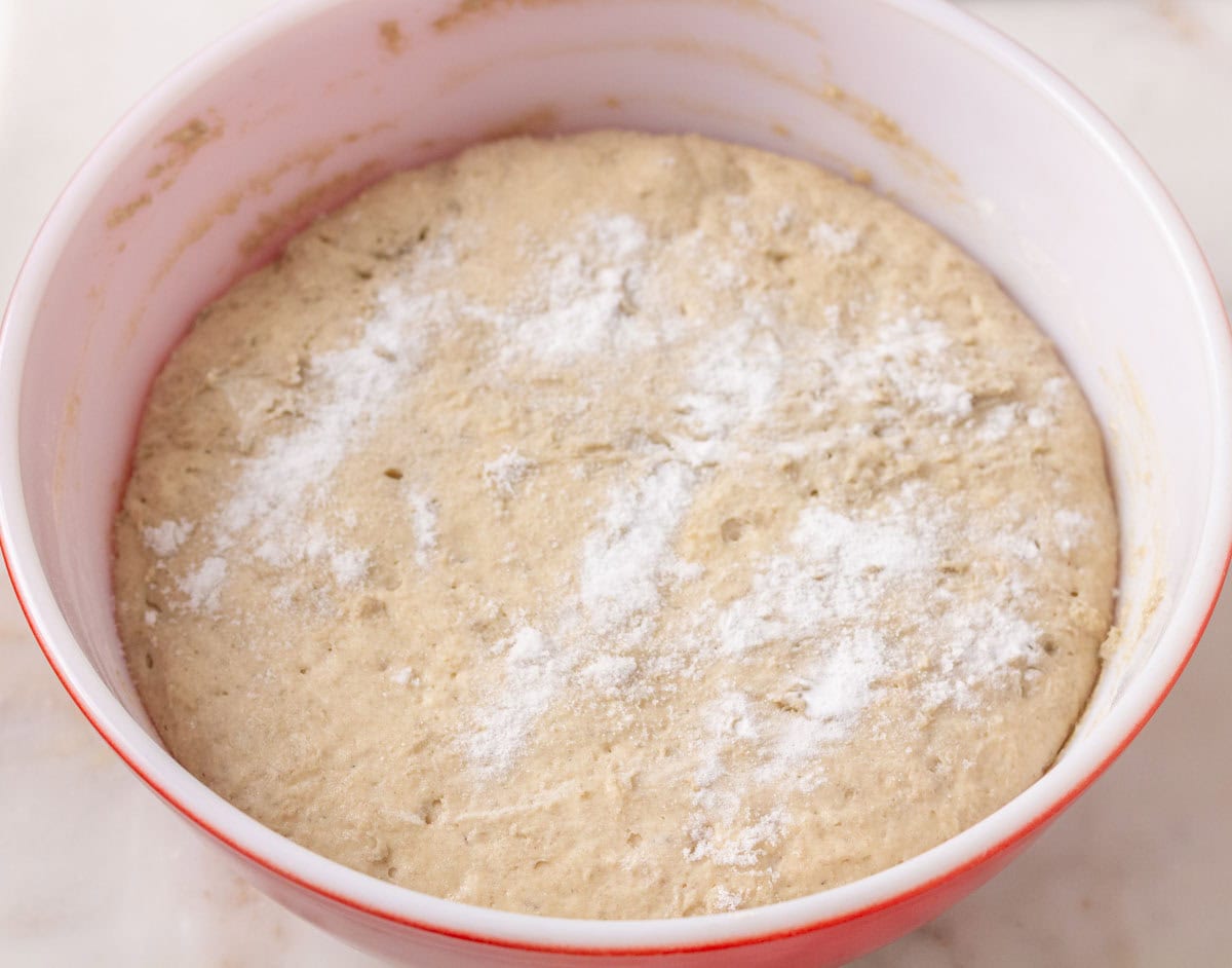 Sourdough Discard English Muffin Recipe | thewendthousekitchen.com Baking soda and salt sprinkled onto English muffin dough that has risen in a large mixing bowl.