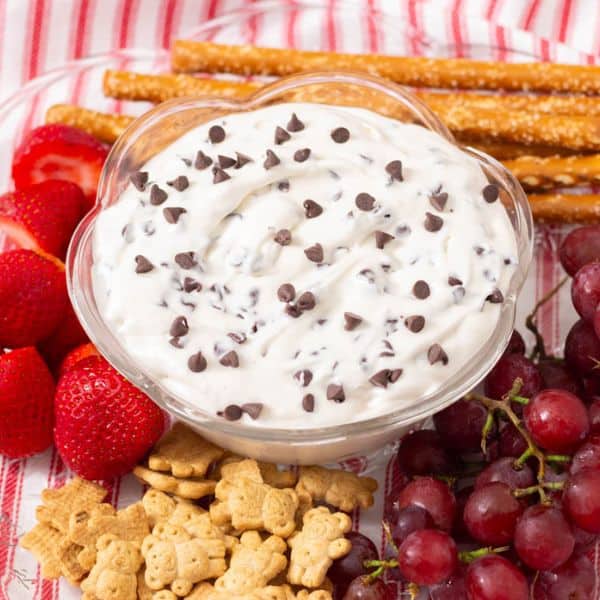 Booty Dip in a glass bowl with fruit, small cookies and pretzels around the bowl.