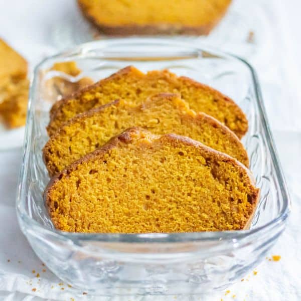 Pumpkin loaf cake sliced in a glass loaf pan.