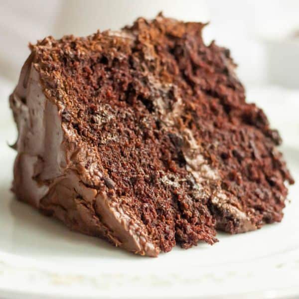 A piece of chocolate cake with chocolate frosting on a plate.
