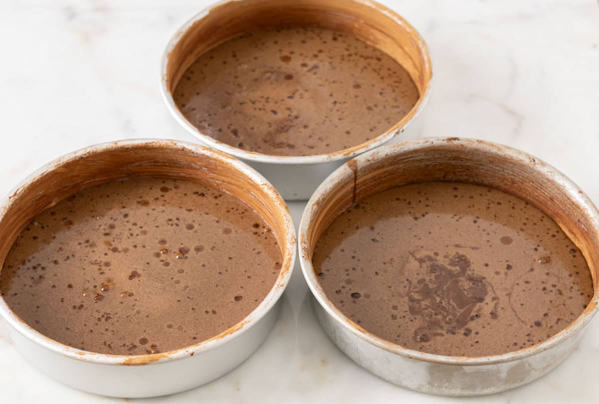 Chocolate Mint Cake with Mint Cream Cheese Frosting | thewendthousekitchen.com Three 8-inch round cake pans with chocolate cake batter inside.