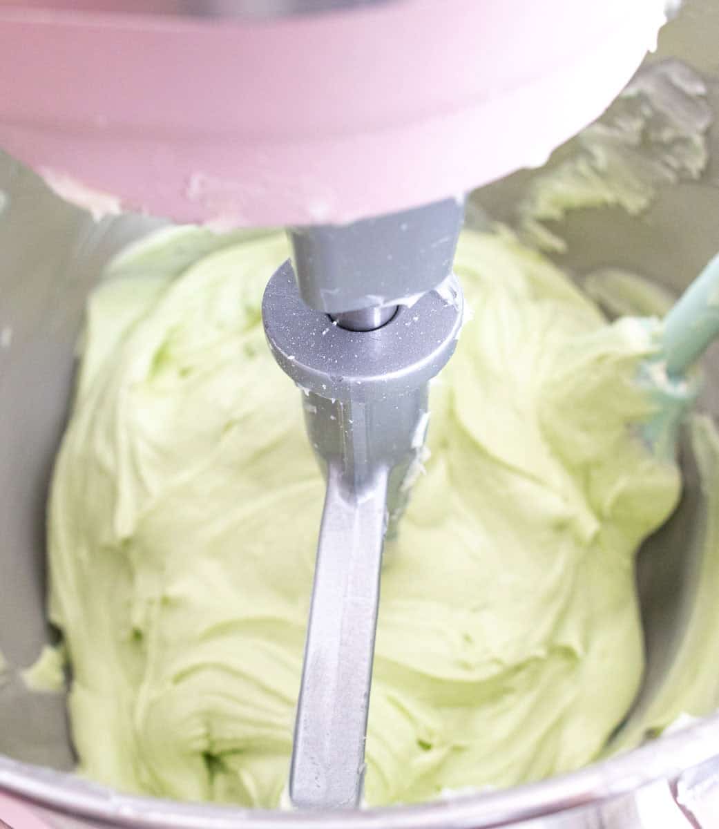 Chocolate Mint Cake with Mint Cream Cheese Frosting | thewendthousekitchen.com Green cream cheese frosting in the bowl of a stand mixer.