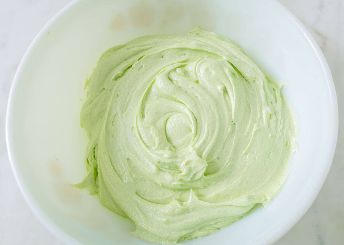 Chocolate Mint Cake with Mint Cream Cheese Frosting | thewendthousekitchen.com Green cream cheese frosting in a large mixing bowl.