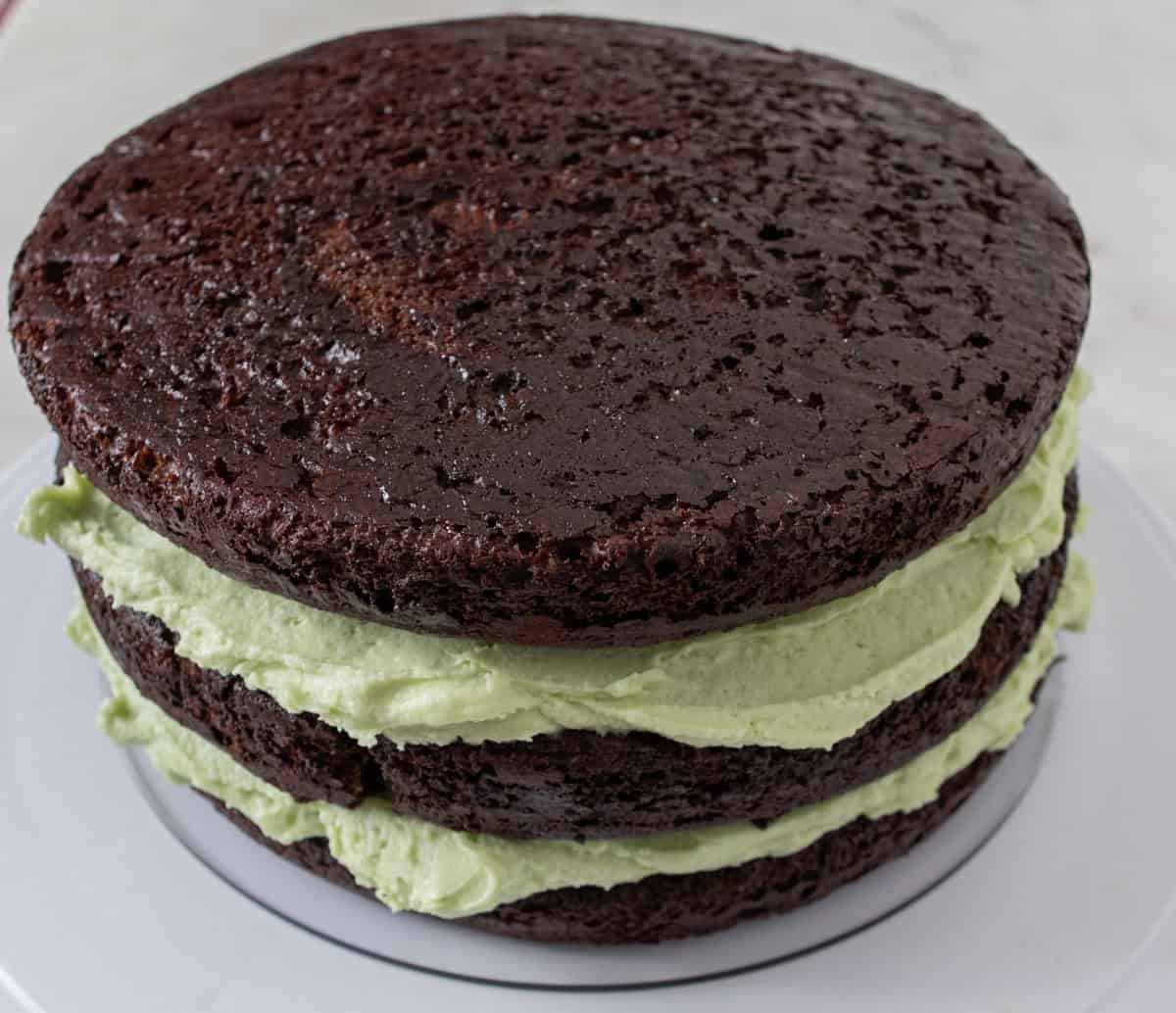 Chocolate Mint Cake with Mint Cream Cheese Frosting | thewendthousekitchen.com Three round layers of chocolate cake filled with green cream cheese frosting.